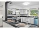 Bright kitchen featuring white cabinets, granite countertops, and stainless steel appliances at 903 Tomahawk Trl, Brandon, FL 33511