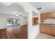 Open-concept living and kitchen area with stainless appliances, wood laminate flooring, and screened patio at 903 Tomahawk Trl, Brandon, FL 33511