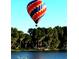 Hot air balloon soaring over a beautiful lake and lush green trees on a sunny day at 919 Ballinger Rd, Lutz, FL 33548