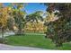 Lush backyard with mature trees and a serene gazebo by the lake at 919 Ballinger Rd, Lutz, FL 33548