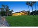 Expansive backyard with a covered patio, gazebo, and lush lawn leading to the waterfront at 919 Ballinger Rd, Lutz, FL 33548