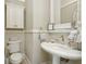 Small, decorative bathroom features an antique bowl sink with matching fixtures and toilet at 919 Ballinger Rd, Lutz, FL 33548