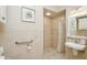 Accessible bathroom featuring a walk-in shower, grab bar, sink, and neutral tile at 919 Ballinger Rd, Lutz, FL 33548
