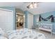 Comfortable bedroom featuring a white bench, closet, ceiling fan, and open doorway to a sitting room at 919 Ballinger Rd, Lutz, FL 33548