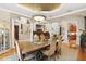 Elegant dining room featuring a chandelier, decorative columns, and seamless transition to the living area and staircase at 919 Ballinger Rd, Lutz, FL 33548
