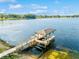 Waterfront property showcasing a private dock with boat lift and scenic lake views on a sunny day at 919 Ballinger Rd, Lutz, FL 33548