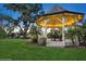 Charming illuminated gazebo with table and chairs, offering a tranquil outdoor space for relaxation and entertaining at 919 Ballinger Rd, Lutz, FL 33548