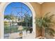 Arched window showcases a serene view of the lake and lush greenery from the home's interior at 919 Ballinger Rd, Lutz, FL 33548