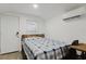 Cozy bedroom featuring a comfortable bed, mini-split AC, and minimalist decor at 1010 Oakhill St, Seffner, FL 33584