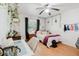 Cozy bedroom decorated with plants, featuring a ceiling fan, window, and a desk at 1010 Oakhill St, Seffner, FL 33584