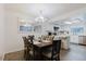 Dining room with chandelier and large window with adjacent modern, white kitchen at 1010 Oakhill St, Seffner, FL 33584