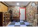 Unique stone wall entryway with shoe storage, a bench, and blue tiled floors at 1010 Oakhill St, Seffner, FL 33584