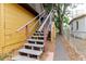 Exterior staircase with wooden railing along the side of the property for access at 1010 Oakhill St, Seffner, FL 33584