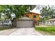 Two-story house with a two-car garage, yellow siding, and stone detailing at 1010 Oakhill St, Seffner, FL 33584