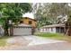 Two-story home featuring a front garage, yellow siding, and stone accents at 1010 Oakhill St, Seffner, FL 33584