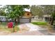 Two-story house with a two-car garage, yellow siding, and stone detailing at 1010 Oakhill St, Seffner, FL 33584
