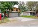 Two-story house with a two-car garage, yellow siding, and stone detailing at 1010 Oakhill St, Seffner, FL 33584