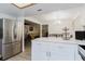 Open concept kitchen with an island, stainless steel refrigerator, and open flow to the dining and living areas at 1010 Oakhill St, Seffner, FL 33584