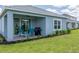 Relaxing back patio with grill, ceiling fan, and manicured lawn is perfect for outdoor entertaining at 10153 Spruce River Way, Parrish, FL 34219