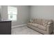 Cozy bedroom showcasing a comfortable couch with decorative pillows, a window, and carpeted floor at 10153 Spruce River Way, Parrish, FL 34219