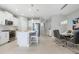 Bright kitchen and dining area featuring white cabinets, stainless steel appliances, and modern lighting at 10153 Spruce River Way, Parrish, FL 34219