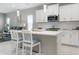 Modern kitchen featuring white cabinets, stainless steel appliances, and a center island with bar seating at 10153 Spruce River Way, Parrish, FL 34219