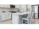 Stylish kitchen with white cabinets, stainless steel appliances, a center island, and light tile flooring at 10153 Spruce River Way, Parrish, FL 34219