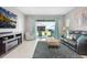 Bright living room featuring a comfortable couch and sliding glass doors to the outdoor patio at 10153 Spruce River Way, Parrish, FL 34219