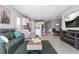 Open concept living room featuring a sofa, kitchen with center island, and adjacent dining area at 10153 Spruce River Way, Parrish, FL 34219