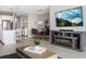Open concept living and dining area, featuring modern furnishings and a large flat screen TV at 10153 Spruce River Way, Parrish, FL 34219