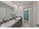 Stylish bathroom with double vanity, granite countertops, and a bright turquoise shower curtain visible in mirror at 10210 White Linen Ave, Riverview, FL 33578