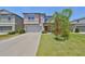 Charming two-story home with a well-manicured lawn, a two-car garage, and an orange front door at 10210 White Linen Ave, Riverview, FL 33578