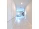 Bright hallway featuring tile flooring, modern wall art, and inviting living space at 10210 White Linen Ave, Riverview, FL 33578