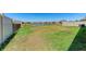 Spacious backyard with black metal fencing, grassy area, and a scenic view of the pond at 10732 Chippewa Dr, Parrish, FL 34219