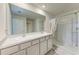 Bathroom with double sink vanity, neutral color palette, and a walk-in shower with glass doors at 10732 Chippewa Dr, Parrish, FL 34219