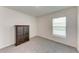 Cozy bedroom with soft carpet, a simple window, and a classic wood cabinet for storage and style at 10732 Chippewa Dr, Parrish, FL 34219