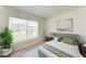 Bright bedroom featuring a comfortable bed with neutral linens, a large window, and modern decor at 10732 Chippewa Dr, Parrish, FL 34219