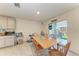 Bright dining area with wood table, chairs, tile floor, and sliding door to the outdoor patio at 10732 Chippewa Dr, Parrish, FL 34219