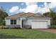 Charming single-story home showcasing stone accents, a two-car garage, and lush landscaping at 11737 Myakka Blue Dr, Venice, FL 34293