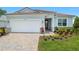 Charming single-story home featuring a paver driveway, well-manicured lawn, and a two-car garage at 11737 Myakka Blue Dr, Venice, FL 34293