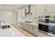 Modern kitchen with a large center island, stainless steel appliances, and stylish gray cabinets at 11737 Myakka Blue Dr, Venice, FL 34293
