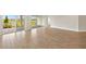 Bright living room with wood-look tile floors and sliding glass doors to a patio with a water view at 11737 Myakka Blue Dr, Venice, FL 34293