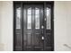 Dark wooden front door with glass panels and silver hardware at 12099 Luxembourg Ct, Spring Hill, FL 34609