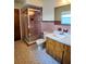 Bathroom featuring a glass-enclosed shower, wood vanity with a sink, and tiled walls at 1262 Jeffords St, Clearwater, FL 33756