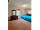 Bedroom with a blue comforter bed, dresser and mirror and natural light from the curtained windows at 1262 Jeffords St, Clearwater, FL 33756