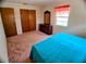 Bedroom showcasing the bed, dresser and closet with warm toned carpet, window and door at 1262 Jeffords St, Clearwater, FL 33756