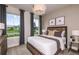 Cozy bedroom featuring a wooden bed frame, neutral decor, and natural light streaming through large windows at 12626 Glenn Creek Dr, Riverview, FL 33569
