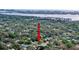 Aerial view of the neighborhood with lush trees, and a distant city view at 1267 Woodlawn Ter, Clearwater, FL 33755