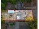 Birds eye view of property boundaries, detached garage, roof, driveway and lush surroundings at 1267 Woodlawn Ter, Clearwater, FL 33755