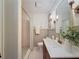 Bathroom featuring a wood vanity with white countertop, shower with updated fixtures and stylish lighting at 1267 Woodlawn Ter, Clearwater, FL 33755